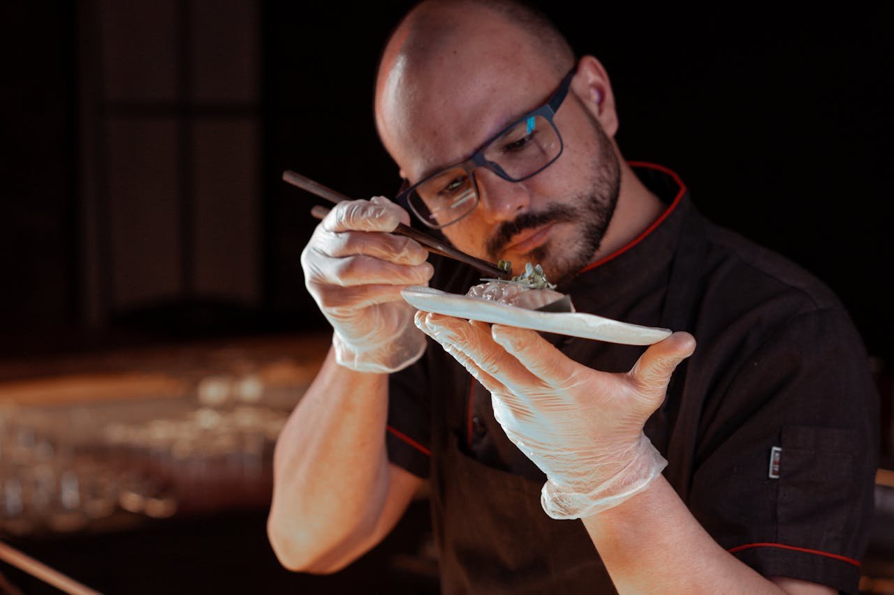 Chef intricately garnishing a gourmet Asian dish, focusing on precision and detail.