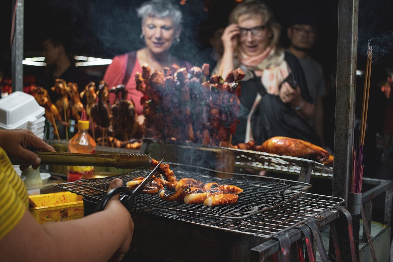 Vibrant street food barbecue scene at Hội An night market, featuring grilled seafood and skewers.